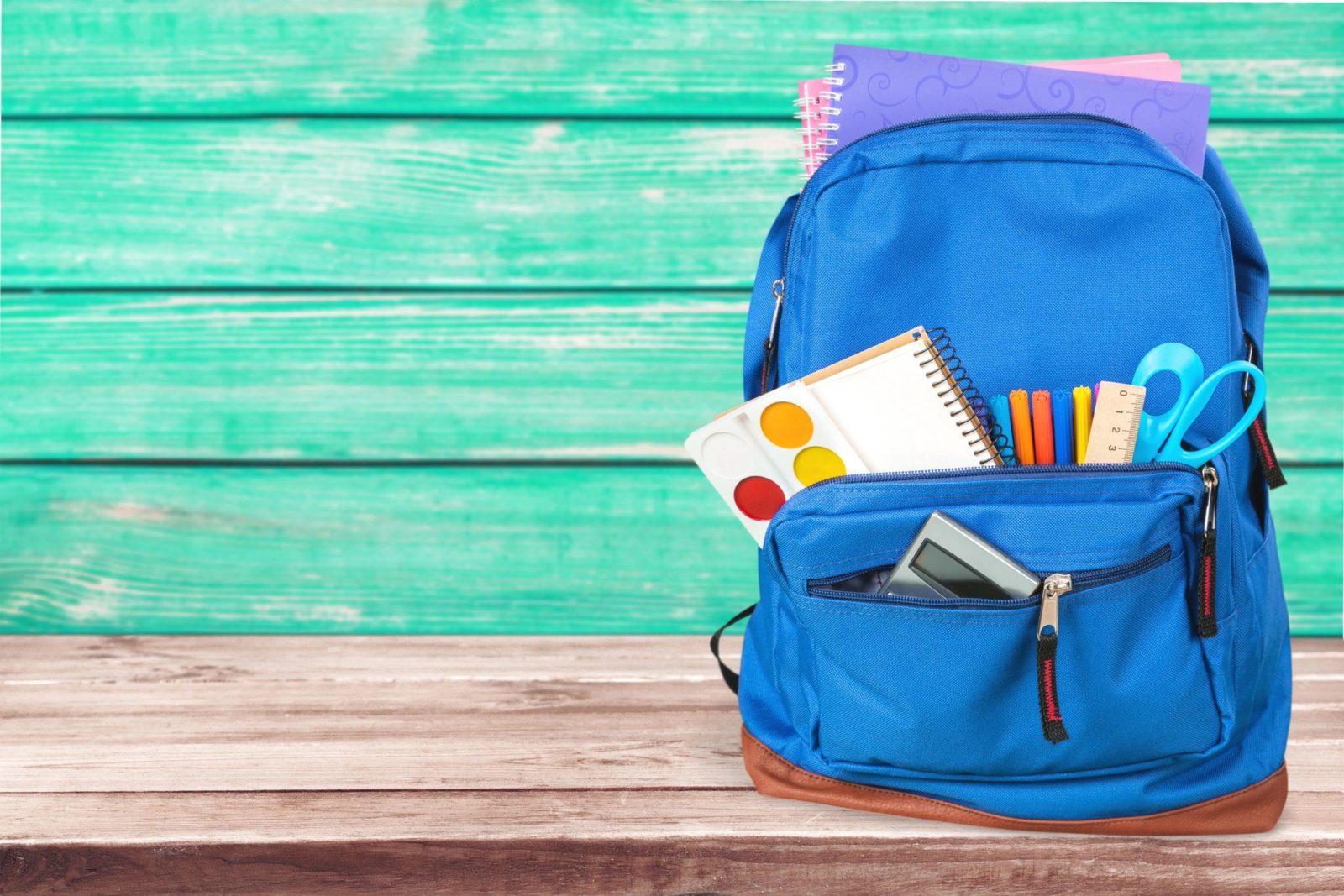 blue bag with school supplies inside